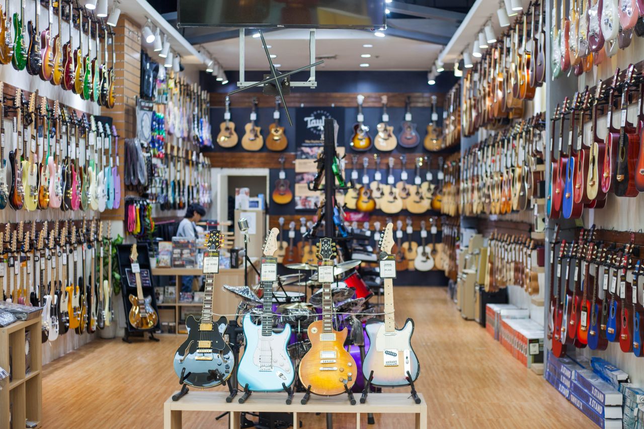 Home A colorful guitar store interior showcasing a wide range of guitars on display. Perfect for music enthusiasts.